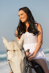 smiling young woman riding a horse
