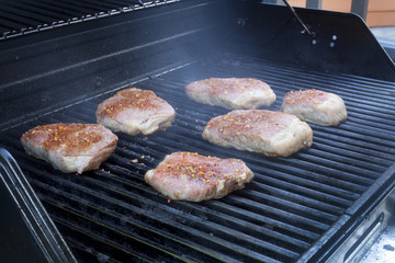 Beef steaks cooking on a grill