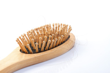 Wooden comb brush with lost hair isolated