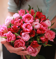 bouquet of red flowers of different colors in the hands of the g