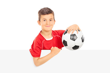 Kid holding a football behind a blank panel