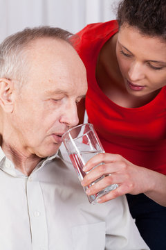 Nurse helping disabled with drinking water