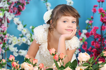 Obraz na płótnie Canvas Pretty little girl in white dress props chin by hand