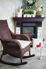 Wicker rocking chair, candlestick and fireplace with candles