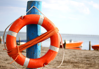 pole with lifejacket at sea on the beach by the sea