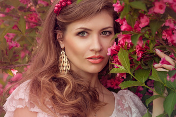 Obraz na płótnie Canvas Closeup portrait of romantic woman with pink flowers