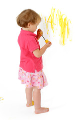 malująca dziwczynka żółtą farbą po ścianie - obrazy, fototapety, plakaty