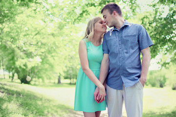 Fototapeta premium Lovely tender young couple in love walking in sunny spring park,