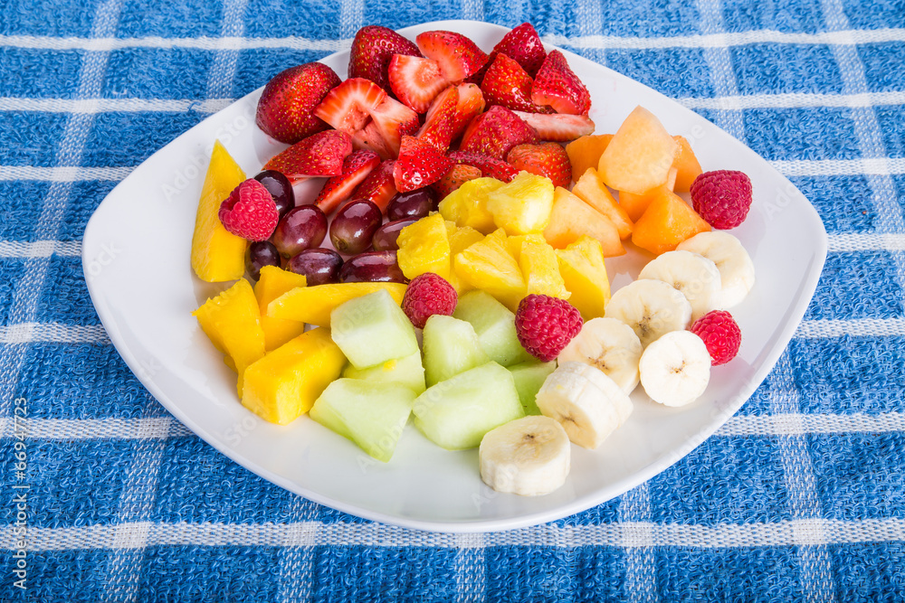 Wall mural Cut and Sliced Fruit on a Square White Plate