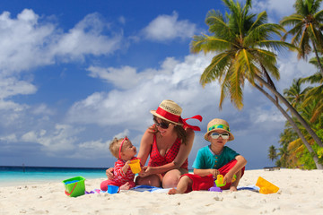 mother and kids playing on tropical beach