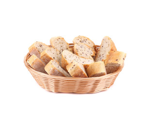 Sliced baguette on wicker basket.