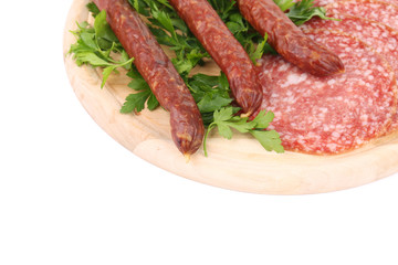 Composition of sausages on wooden platter.