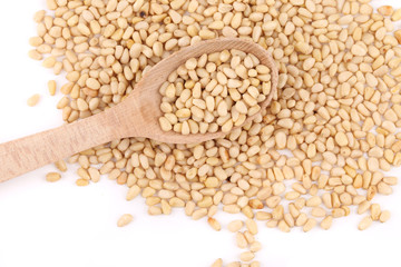 Wooden spoon full with pine nuts.