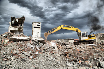 Bulldozer removes the debris from demolition of old buildings