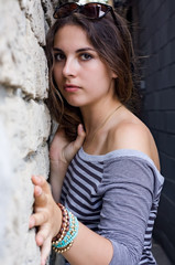 Girl in striped shirt by stone wall