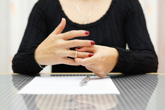 break up . Woman is taking off the ring from hand