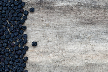 Dried aronia berries on wooden background