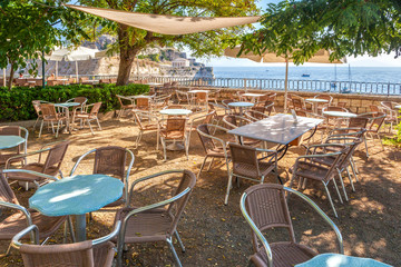 Empty tables in cafe near old venetian fortress