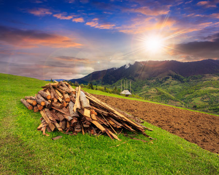 lumber on agriculture field in mountains at sunset