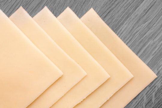 Sliced Cheese Neatly Arranged On A Wood Surface. From Above.