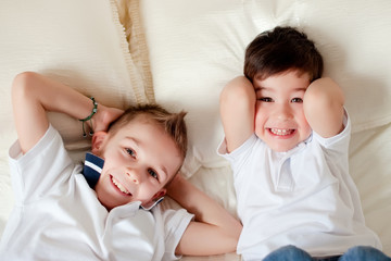 Two boys having fun in bed at home