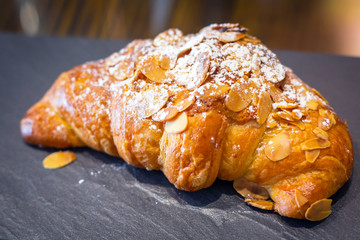 Fresh croissant with almonds on the plate