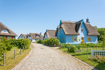 thatched-roof vacation house settlement - obrazy, fototapety, plakaty