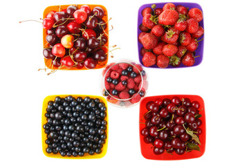 colored berries in bowls and white background