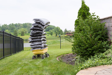 Mulch in bags piled high on a cart in the garden