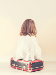 Sad little girl with a suitcase