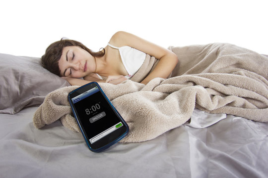 female snoozing modern cell phone alarm clock