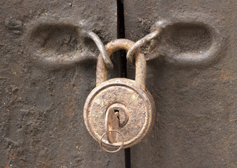 Old rusty padlock on a  iron door closeup
