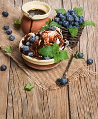 White ice cream with berries and leaf of mint and chocolate jam