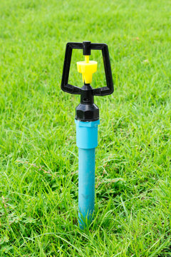 sprinkler in green grass garden