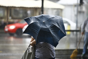 Woman walking with umbrellas in the rainy city