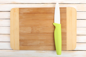 Kitchen knife and cutting board on wooden table