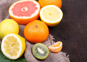 Fresh exotic fruits with green leaves on color wooden