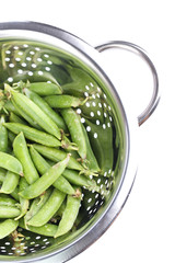 Fresh green peas in colander isolated on white background