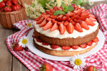 Delicious biscuit cake with strawberries on table close-up