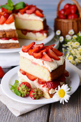 Delicious biscuit cake with strawberries on table close-up