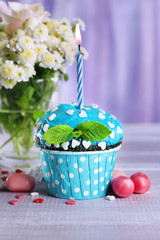 Tasty cupcake on table, on fabric background