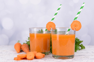 Glasses of carrot juice with fresh carrots and parsley