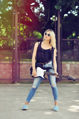 Beautiful woman with sunglasses with electric guitar