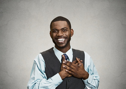 Happy, surprised young businessman, grey wall background 