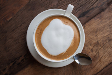cup of cappucino on wooden table