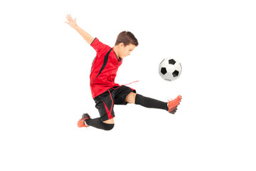 Fototapeta na wymiar Junior football player kicking a ball