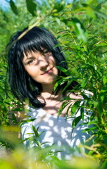 Beautiful girl in green foliage