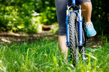 Closeup of woman riding mountain bike outdoors.