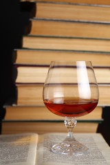 Glass of brandy on books