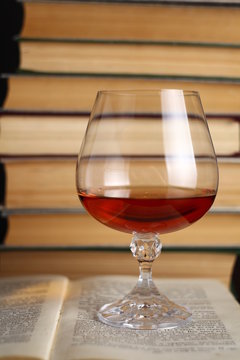 Glass of brandy on books